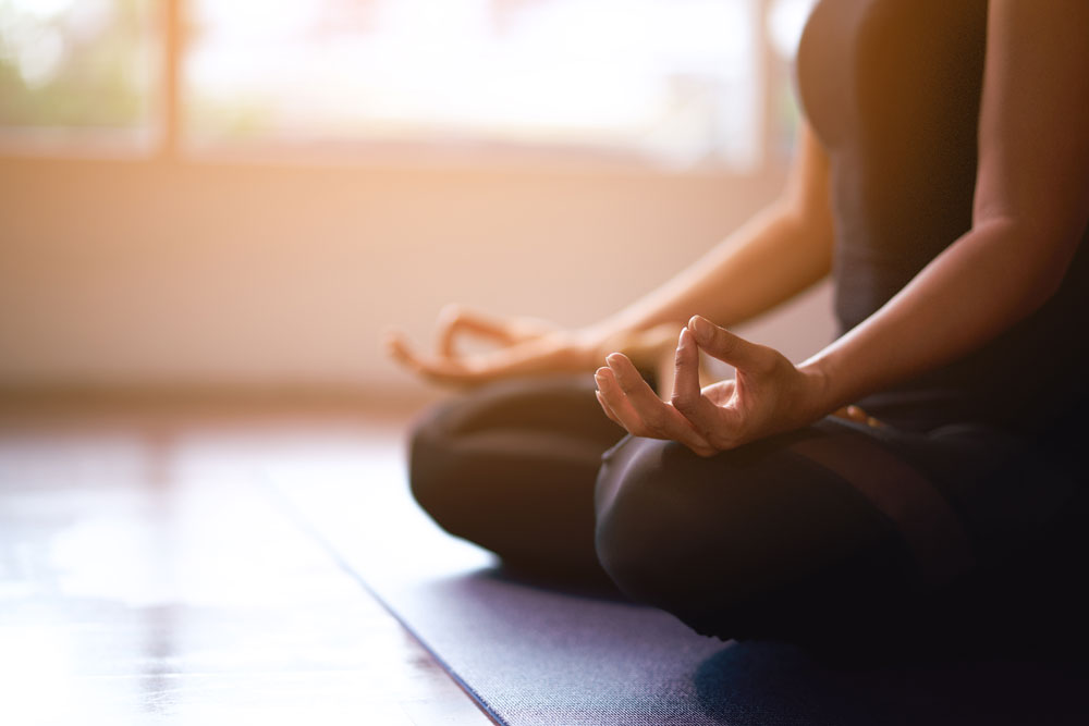 Woman sitting on the floor meditating.